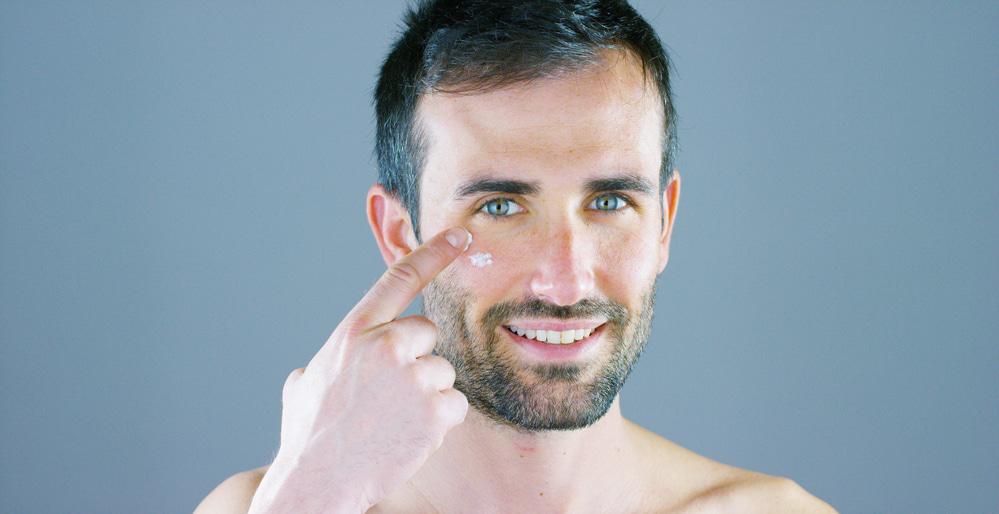 man applying eye cream for men
