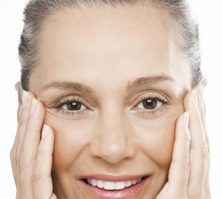 mature woman performing facial exercises