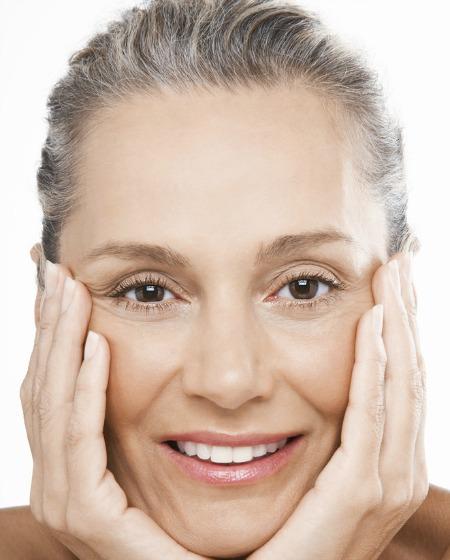 mature woman performing facial exercises