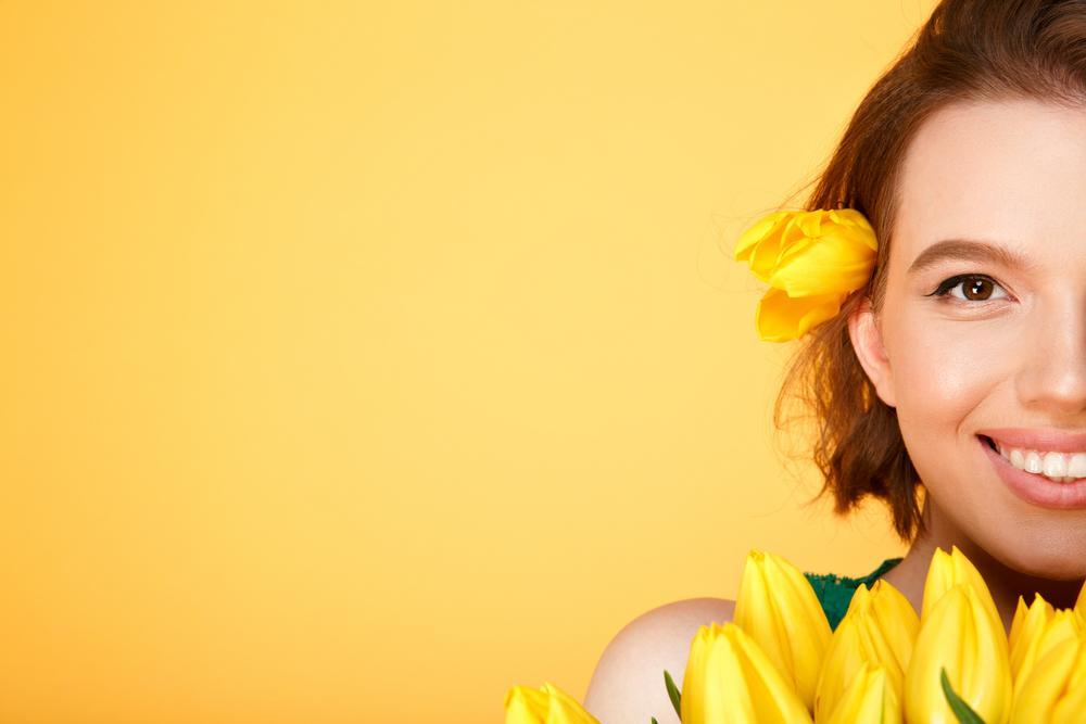 woman without fine lines holding flowers