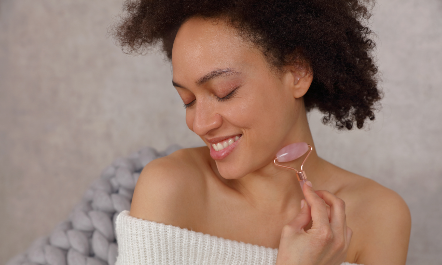 woman using rose quartz face roller