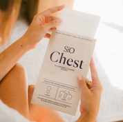 Person holding a package of 'Sio Chest' patches with a blurred background