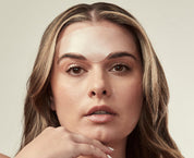 Woman with bare shoulders against a neutral background