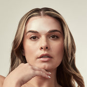 Woman with bare shoulders against a neutral background