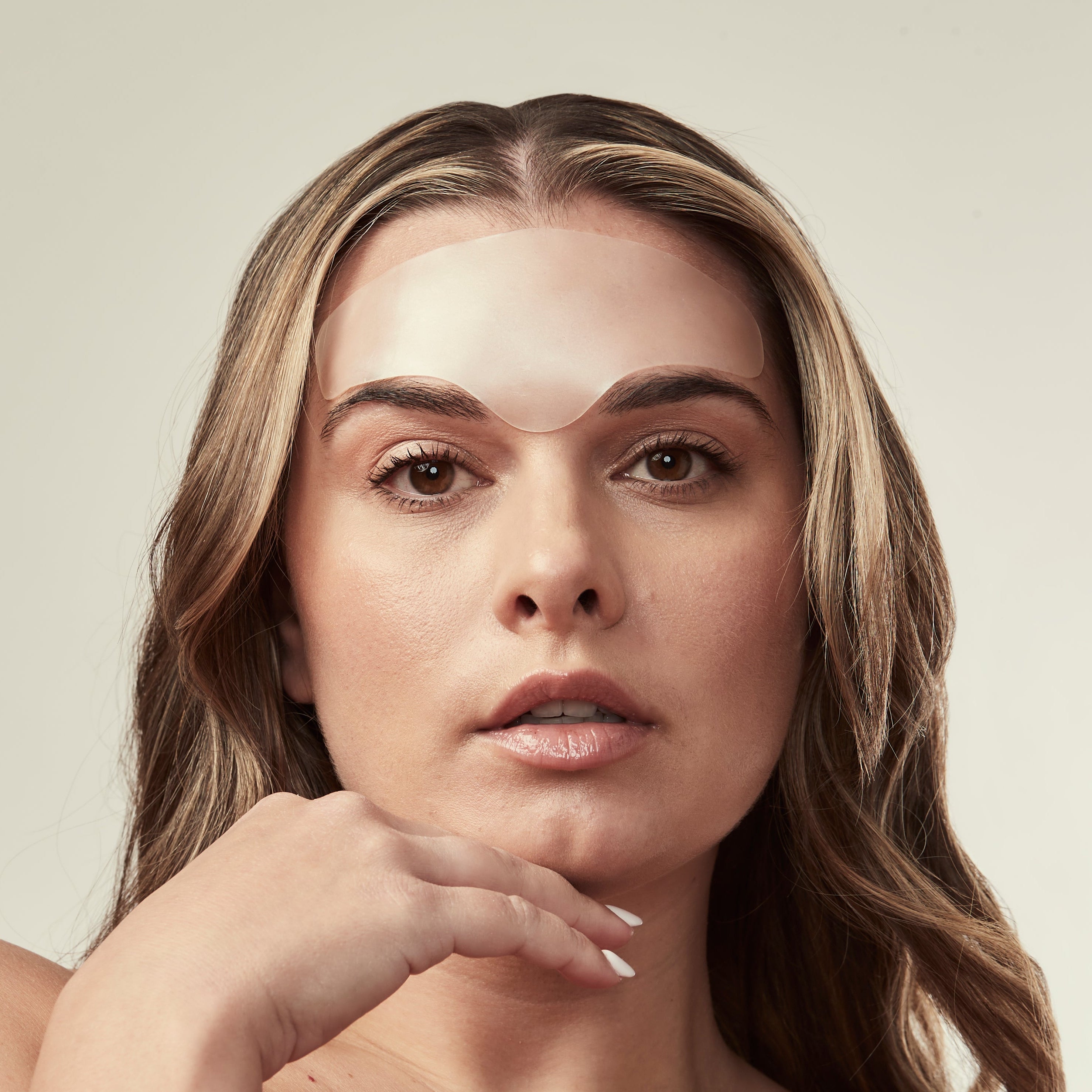 Woman with bare shoulders against a neutral background